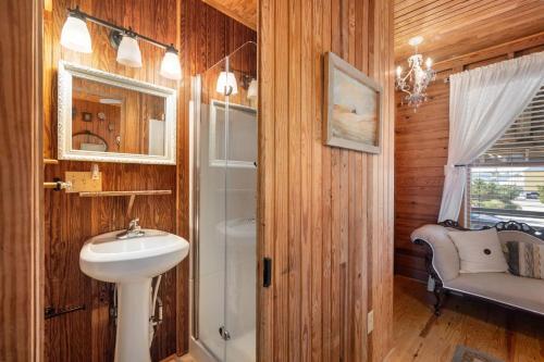 ein Badezimmer mit Waschbecken, Dusche und Spiegel in der Unterkunft NH315 Serenity by the Sea in Nags Head
