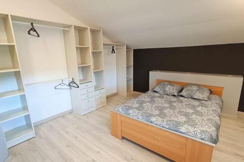 - une chambre avec un lit et quelques étagères blanches dans l'établissement Maison, à Neuvic
