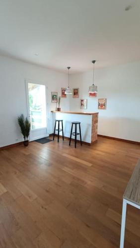 un salon vide avec une table et deux tabourets dans l'établissement Maison, à Neuvic