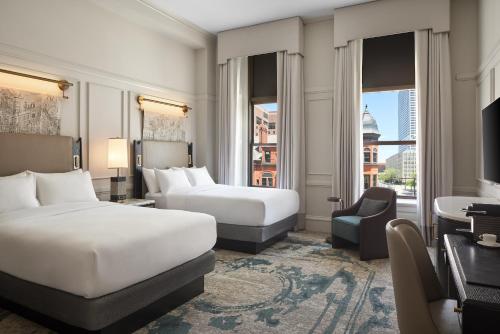 ミルウォーキーにあるThe Pfister Hotelのベッド2台と机があるホテルの部屋
