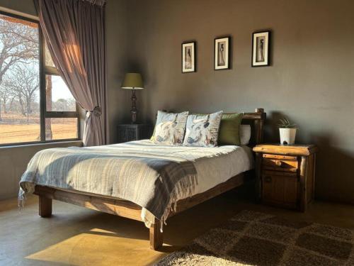 a bedroom with a large bed and a window at Camel Creek Safari Lodge in Thabazimbi
