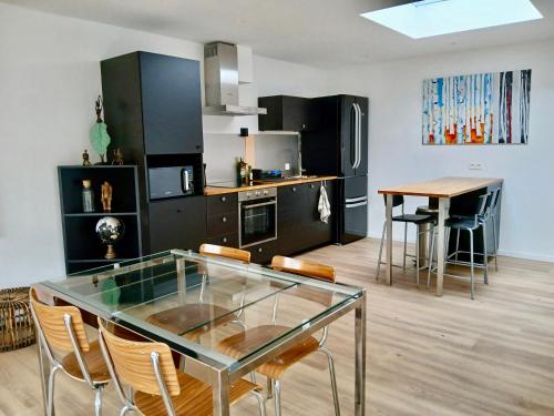 - une cuisine avec une table en verre et des chaises dans l'établissement Appartement du peintre, à Theux