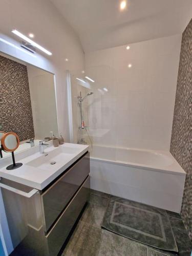 une salle de bain avec un lavabo, une douche et une baignoire dans l'établissement Appartement atypique clair et spacieux avec jardin, à Trouville-sur-Mer