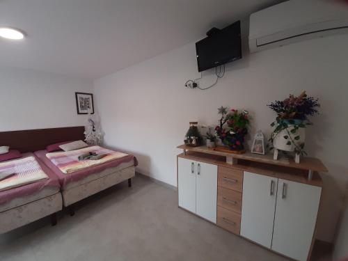 a room with a bed and a desk and a tv at Apartmani Show Zagreb in Zagreb