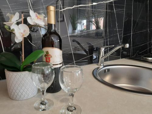 two wine glasses sitting on a counter next to a sink at Apartmani Show Zagreb in Zagreb