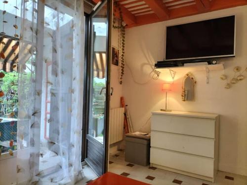 Cette chambre dispose d'une télévision, d'une commode et d'une fenêtre. dans l'établissement Jolie maison, à Vence