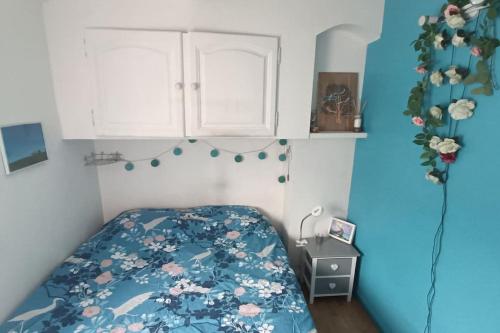 - une petite chambre avec un lit et une couverture bleue dans l'établissement Jolie maison, à Vence