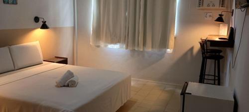 a bedroom with a bed with a towel on it at Hotel San Conrado in Salinópolis