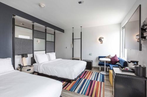 a hotel room with two beds and a desk at Aloft Austin Round Rock in Round Rock