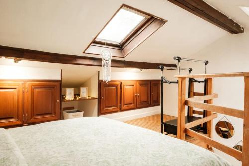 - une chambre avec un grand lit et une lucarne dans l'établissement Logement entier Maison, à Versailles