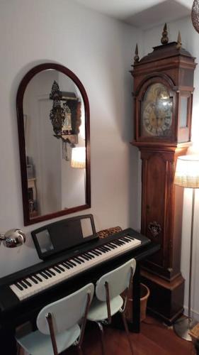 un miroir, un piano et une horloge dans une pièce dans l'établissement Pantin Canal de l'Ourcq, à Pantin