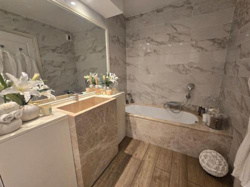 une salle de bain avec une baignoire et un lavabo dans l'établissement T2 RDJ La Louvière Saint Raphaël front de mer, à Saint-Raphaël