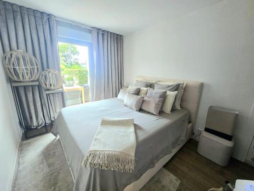 une chambre avec un grand lit blanc avec une fenêtre dans l'établissement T2 RDJ La Louvière Saint Raphaël front de mer, à Saint-Raphaël