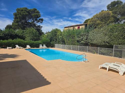 - une piscine dans une cour avec des chaises et une clôture dans l'établissement T2 RDJ La Louvière Saint Raphaël front de mer, à Saint-Raphaël