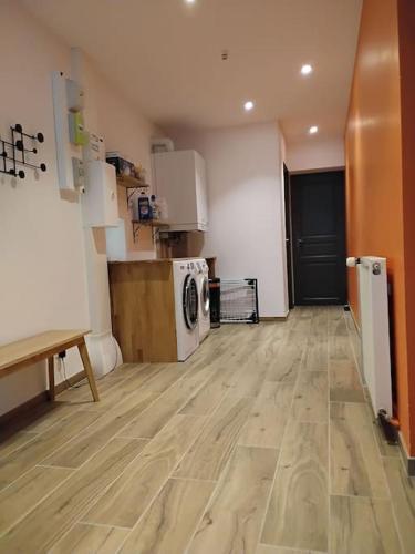 a room with a kitchen with a wooden floor at Maison familiale dans le Perche in Val-au-Perche