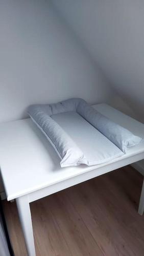 a white bench with two pillows on it at Maison familiale dans le Perche in Val-au-Perche