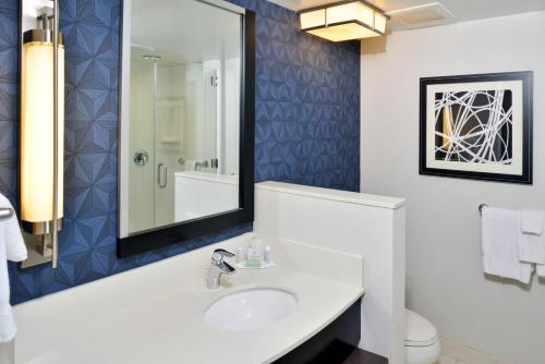 a bathroom with a sink and a mirror at Courtyard by Marriott Wilmington Downtown/Historic District in Wilmington