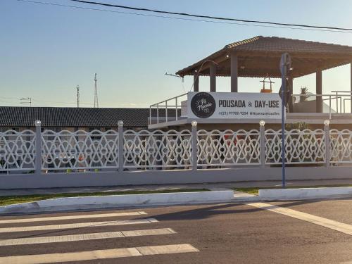 a white fence on a bridge with a gazebo at Suítes Pé Nareia Itaipuaçu in Maricá