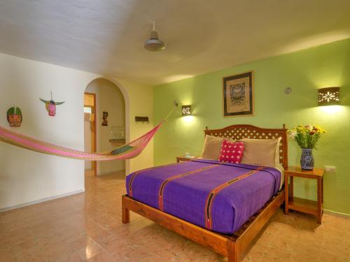 a bedroom with a bed with a hammock in it at Casa Del Maya Bed & Breakfast in Mérida