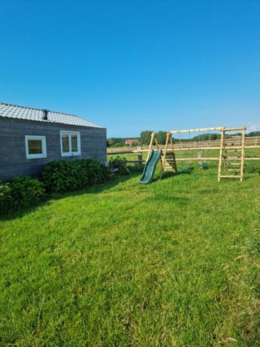 a yard with a playground and a house at Chalet Vue Mer, terrasse, nature, poney à disposition in Dieppe