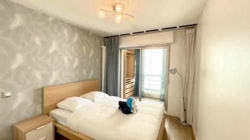 une chambre avec un lit avec un animal en peluche dessus dans l'établissement 129 - Splendeur Confort et Modernité, Terrasse au Cœur de Paris, à Paris