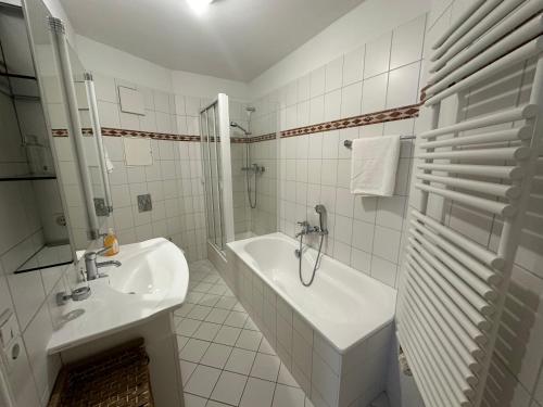 a white bathroom with a tub and a sink at Ferienwohnung in Bad Saarow in Bad Saarow