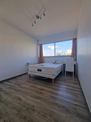 une chambre avec un lit et une grande fenêtre dans l'établissement T5 4 chambres, à Marseille