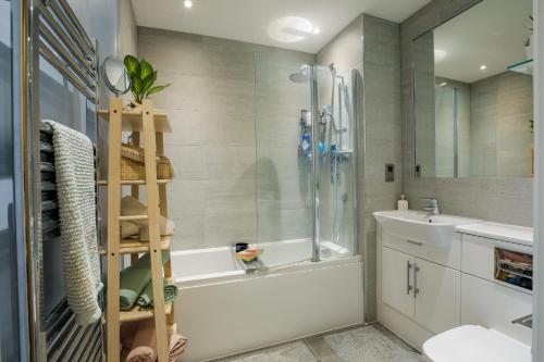 a bathroom with a shower and a tub and a sink at Birmingham City Stay Apartments in Birmingham