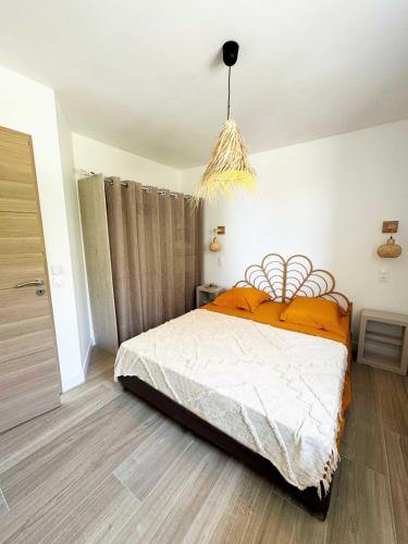 une chambre avec un lit et un lustre dans l'établissement La Villa Dina, à Carqueiranne