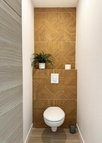 La salle de bains est pourvue de toilettes et d'un mur en bois. dans l'établissement La Villa Dina, à Carqueiranne