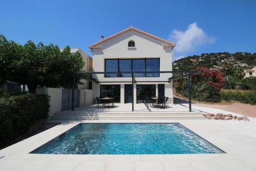 une maison avec une piscine devant une maison dans l'établissement La Villa Dina, à Carqueiranne