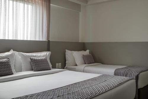 two beds sitting next to each other in a bedroom at HCM - Hotel Corais de Manaira in João Pessoa