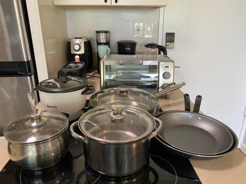 a kitchen with several pots and pans on a stove at Amazing View Waikiki Beach 28th Floor 1BR Family and Group Condo in Honolulu