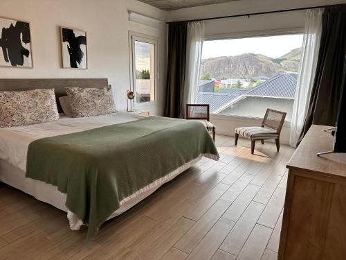 ein Schlafzimmer mit einem Bett und einem großen Fenster in der Unterkunft Patagonia Hikes Aparts in El Chalten