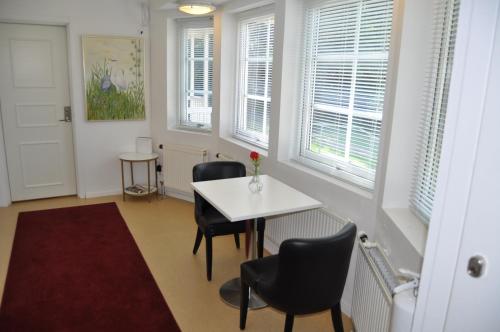 a room with a table and chairs and windows at långstorp in Höör