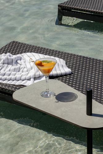 a drink sitting on a table next to a pool at HCM - Hotel Corais de Manaira in João Pessoa