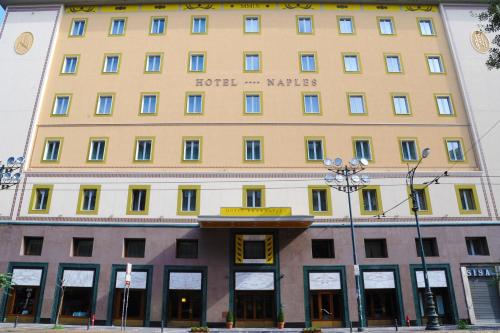 a large yellow building on a city street at Hotel Naples in Naples