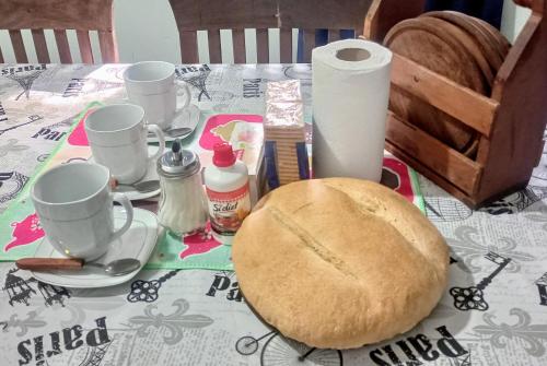un tavolo con un piatto di pane e tazze sopra di Alojamiento Naomi 1 a Villa Unión