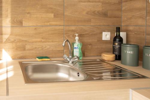 a stainless steel sink in a kitchen with wooden walls at Jungle appartement lumineux plein centre in Boulogne-sur-Mer