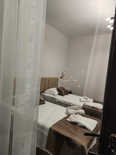 2 camas en una habitación con cortinas blancas en sea side, en Makhinjauri