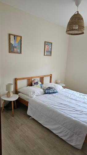 une chambre avec un lit et une table avec une lampe dans l'établissement Maison familiale Cazaux, à La Teste-de-Buch