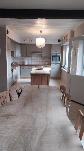 a large kitchen with a large wooden table and chairs at La Vie Est Belle in Kortemark