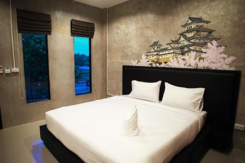 a bedroom with a large white bed with a chinese wall at B-Cozy Hotel in Uttaradit