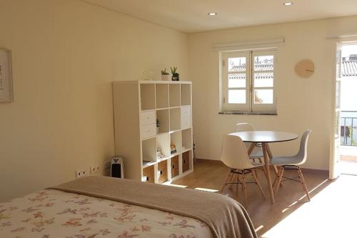 a bedroom with a bed and a table and chairs at Cute Home in Tavira
