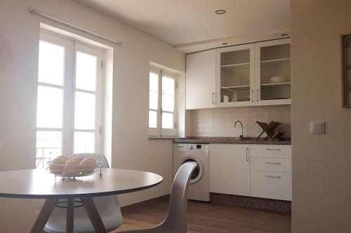 a kitchen with a table and chairs and a sink at Cute Home in Tavira