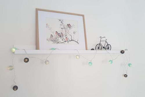 a white shelf with a picture and lights on it at Cute Home in Tavira