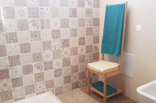 a bathroom with a blue towel on a tile wall at Cute Home in Tavira