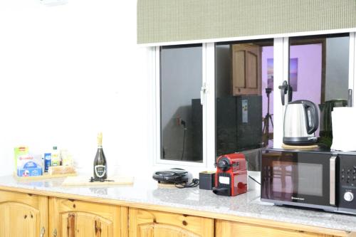 a kitchen counter with a microwave and a window at Sunset view Suite in Trou dʼ Eau Douce