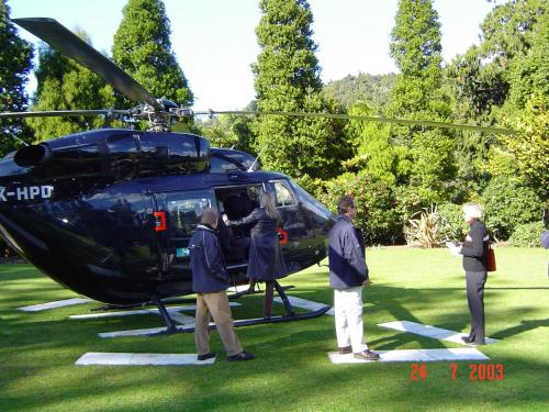 a group of people standing next to a helicopter at Waitakere Resort & Spa in Auckland
