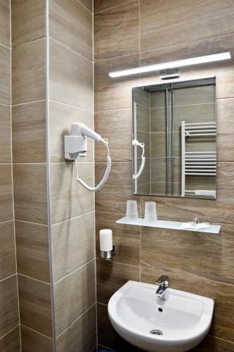 a bathroom with a sink and a mirror at Tömörkény utcai vendégház in Mórahalom
